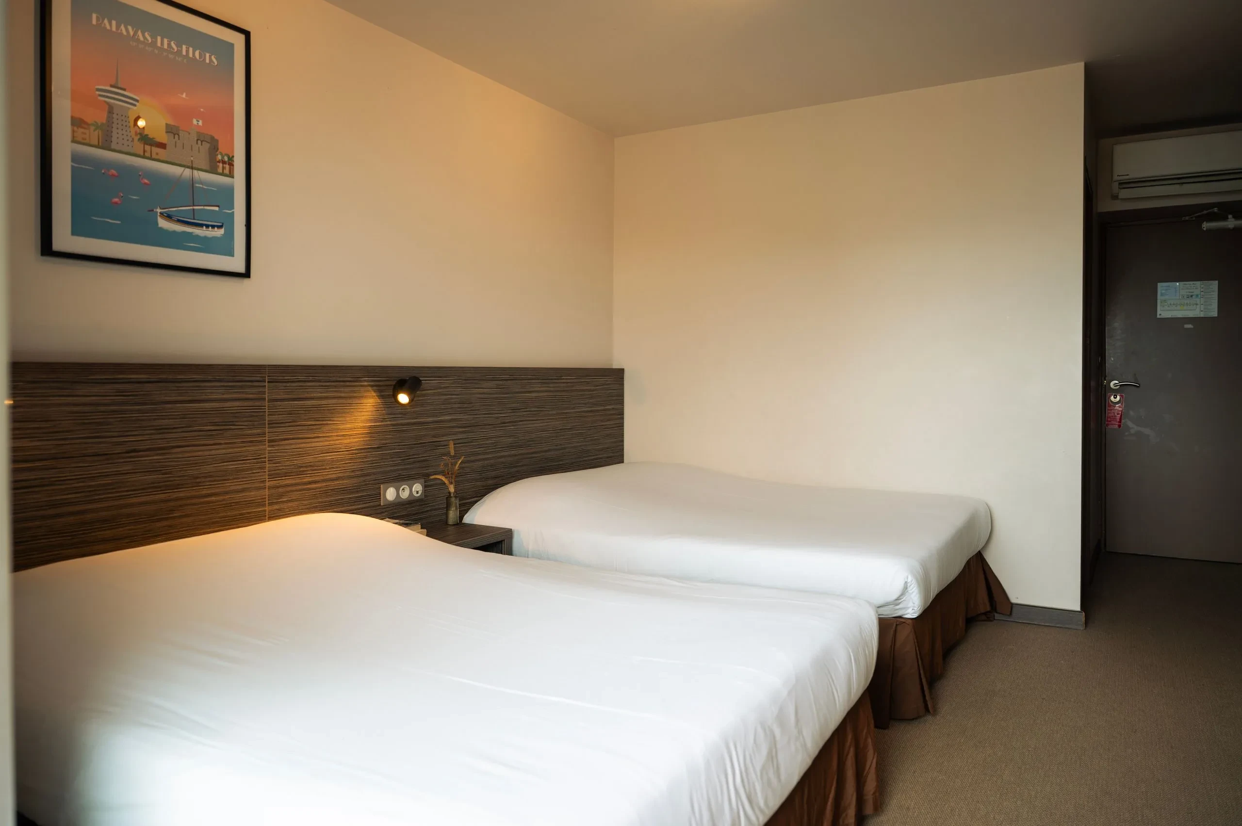 Chambre d'hôtel avec deux lits simples.