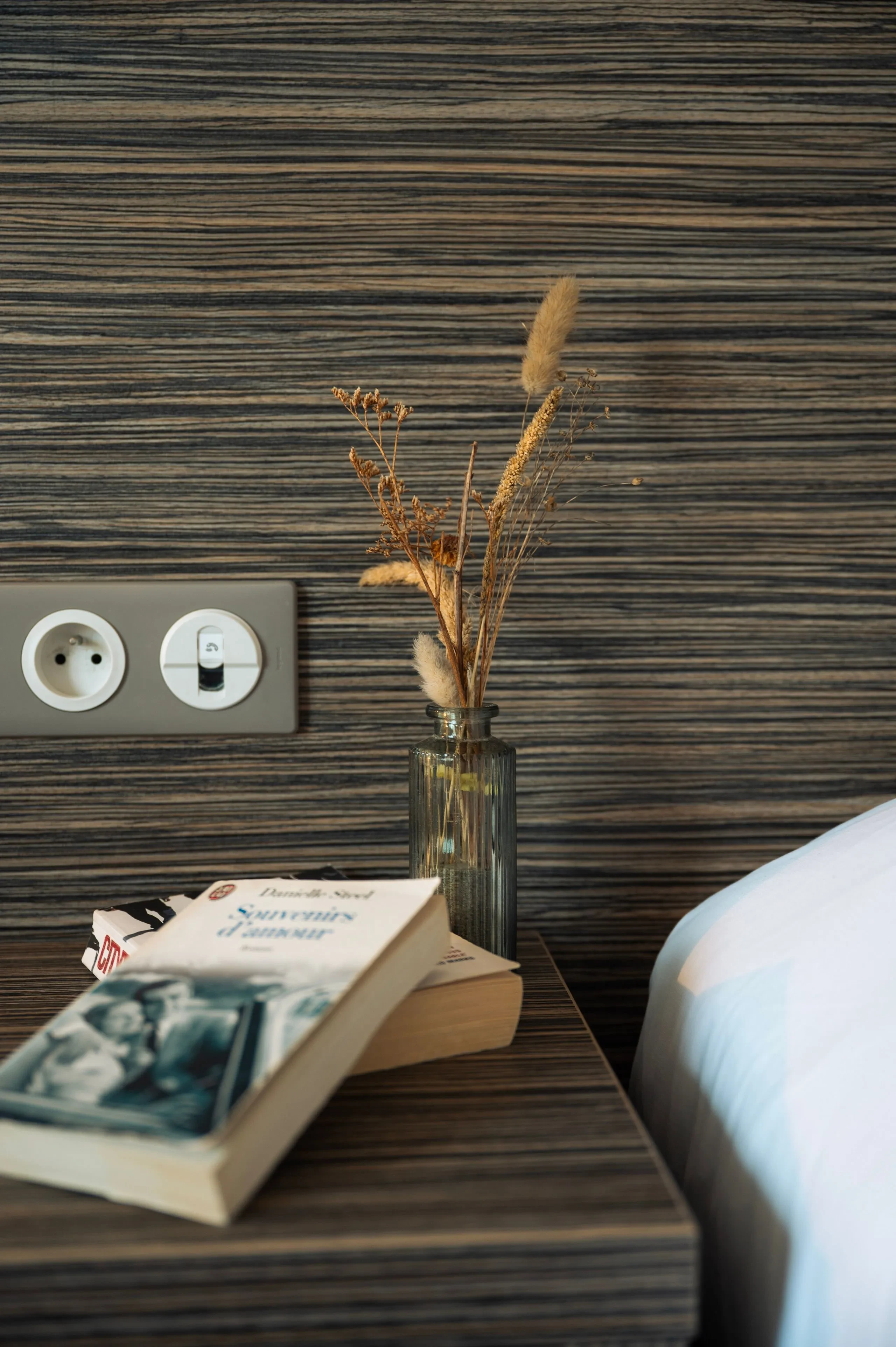 Table de chevet avec livres et vase.