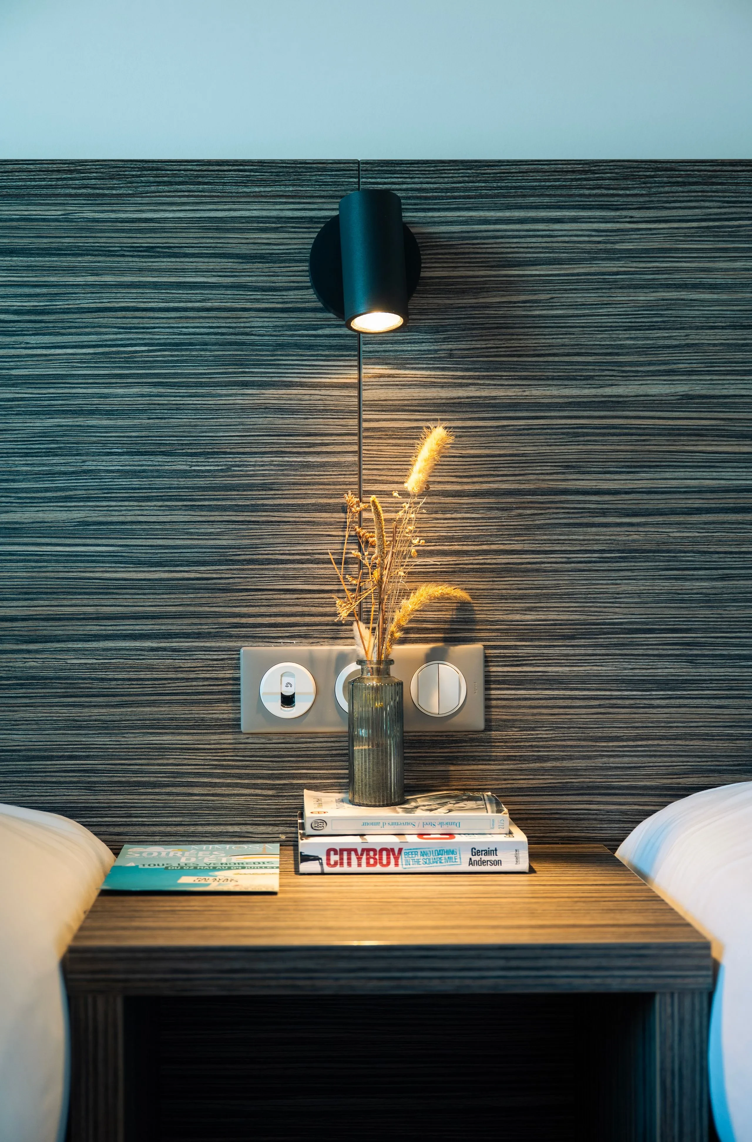 Table de chevet avec lampe et livres.