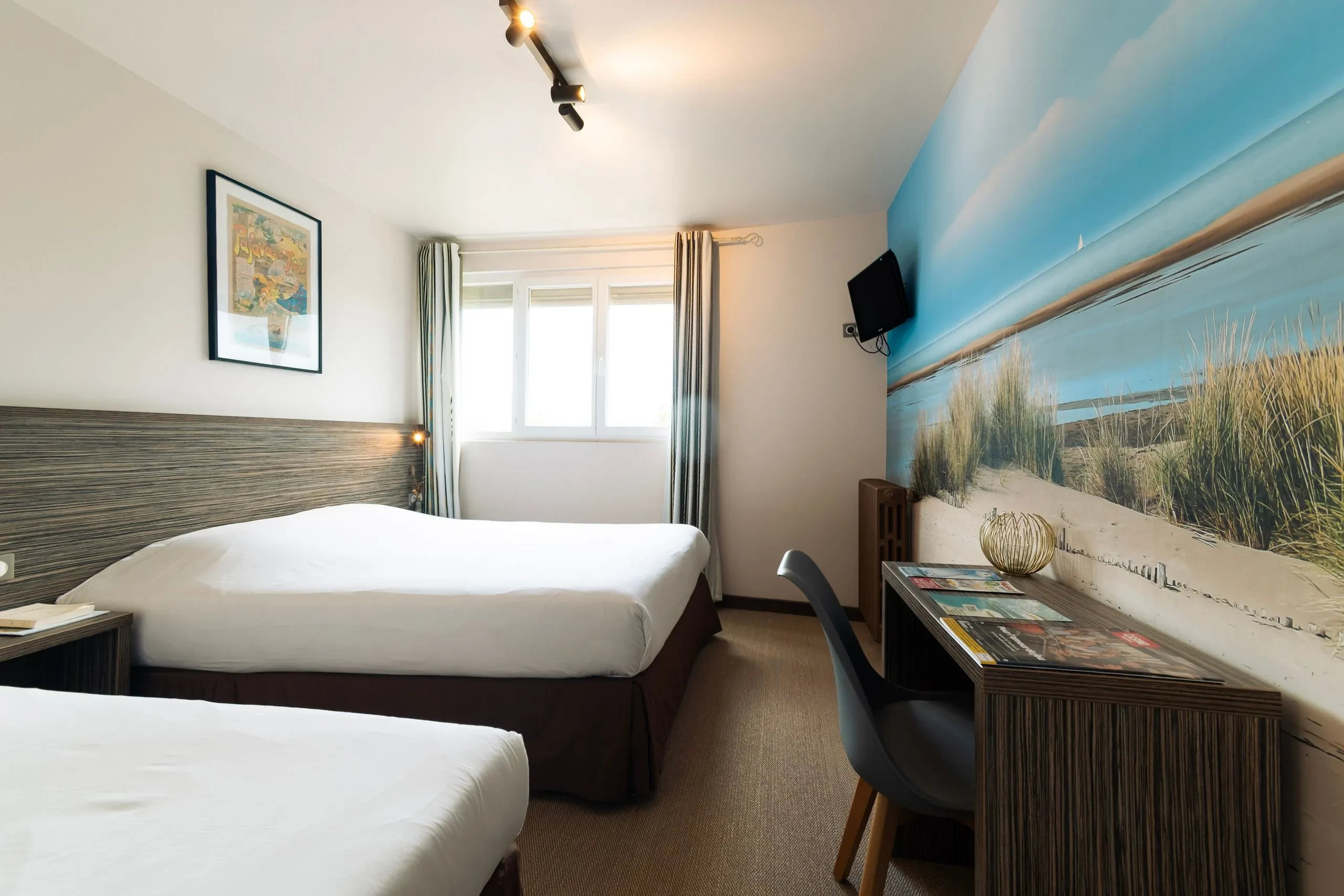 Chambre d'hôtel moderne avec deux lits doubles.