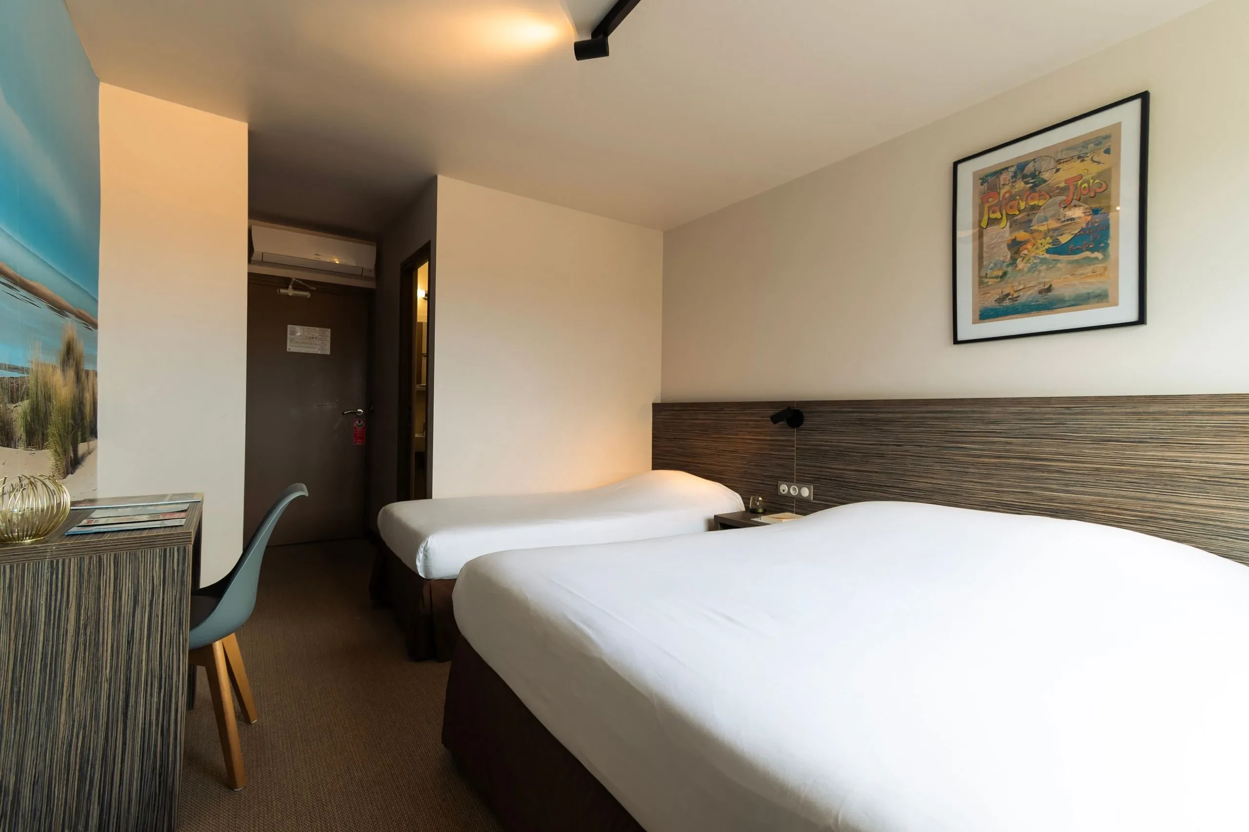 Chambre d'hôtel avec deux lits simples.