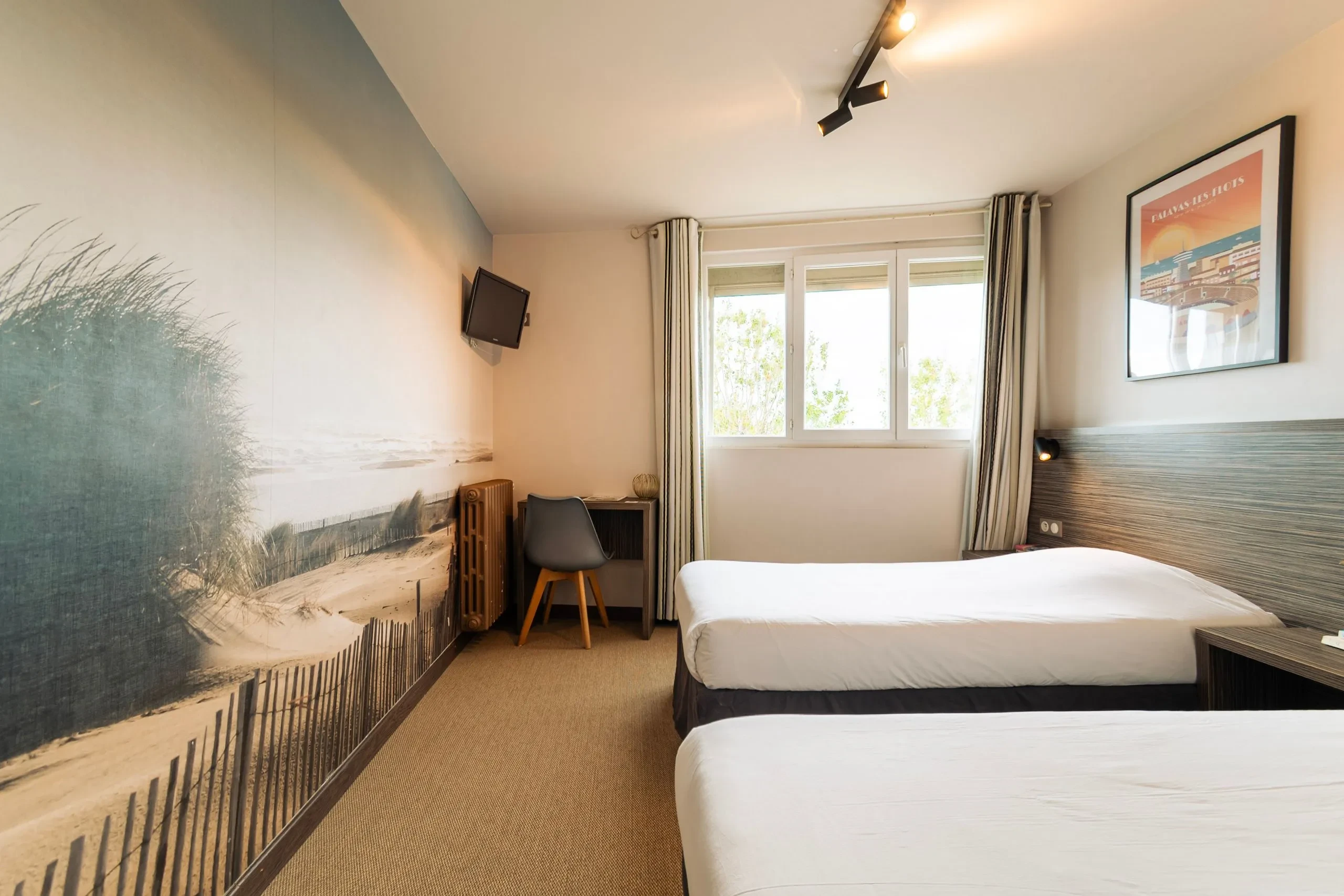 Chambre d'hôtel avec deux lits et décoration plage.