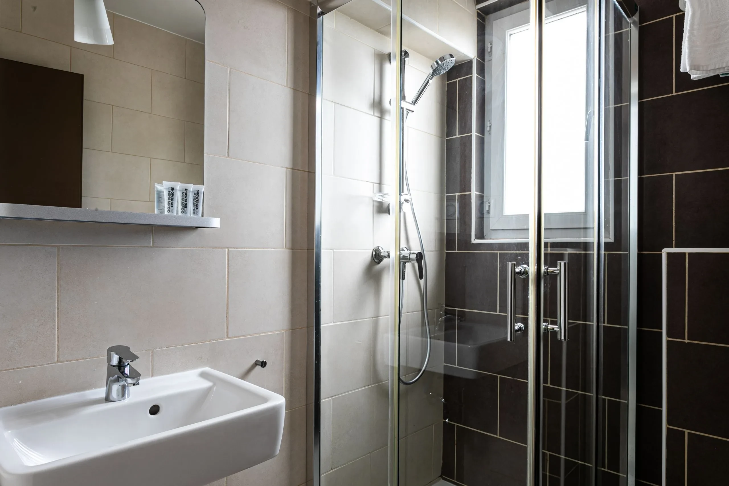 Salle de bain moderne avec douche et lavabo.